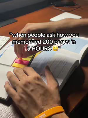 Image shows a person's hands interacting with a textbook and sticky notes on a desk. The focus is on the hands turning the pages and a message overlayed with text.
