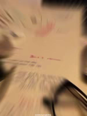 The image has a blurred effect, but appears to be a close-up of a paper with handwriting on it. The composition has a warm color tone. Some text can be seen.