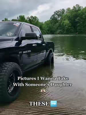 A black pickup truck is partially submerged in a lake, with trees and a cloudy sky in the background. Text overlays the image.