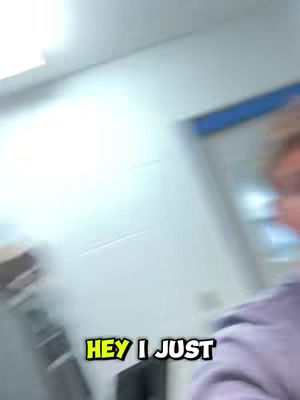 An interior shot with a blurred background of a room, likely a study area. A bit of a person is captured from the front wearing a hoodie in the right area of the frame.