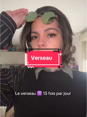 A young woman with dark hair wearing glasses. She has her hand up to her head. A text box that says "Verseau" overlays the image.