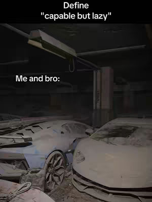The image shows two cars, a Lamborghini and another car, coated in a layer of dust or debris in a dimly lit environment.