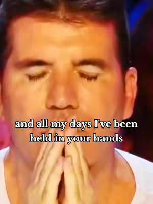 The cover image is a close-up of Simon Cowell with his eyes closed and hands clasped in front of his face, conveying a moment of emotion. Text overlayed on the image reads, "and all my days I've been held in your hands."
