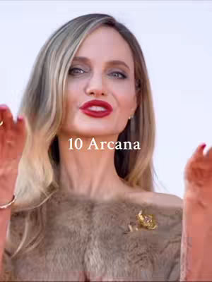 A woman with long blonde hair and red lipstick is the focal point of this cover image. The text overlay reads "10 Arcana". The woman is adorned with a fur-like shawl and a gold brooch.