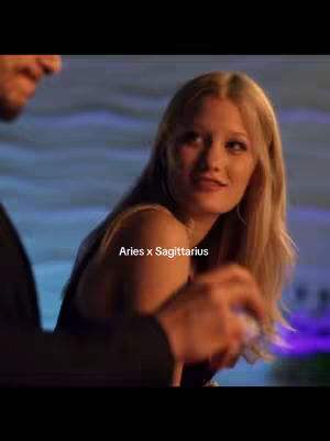 The cover image features a woman looking towards the right, with a man partially visible to the left. Text overlayed reads "Aries x Sagittarius". The background suggests a lit environment, and the color palette includes dark tones with some lighter shades.