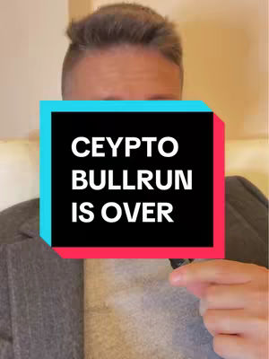 A man is centered in the frame, with his face partially visible above a rectangular text overlay. The text overlay has a turquoise and red border, and reads "CEYPTO BULLRUN IS OVER" in bold white font against a black background. The man is wearing a grey suit jacket over a lighter colored shirt. The background is plain.