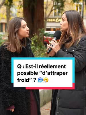 The image shows two women in an outdoor setting. The woman on the right is holding a microphone and speaking. A text overlay in a rectangular box with colored background is in the image with a question. The background is blurred, suggesting a park or urban environment.