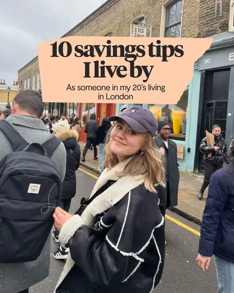 A woman in a black jacket and a cap smiles for the camera, set against a blurred street scene with shops and pedestrians. A text overlay announces '10 savings tips I live by' on a textured background.