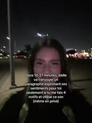 A selfie taken at night with a blurry background of city lights. The foreground features a woman's face, and overlaid text in French.