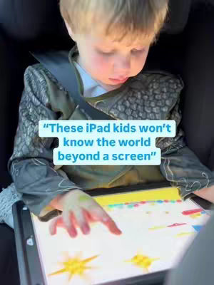 A young boy wearing a costume sits in a car seat, looking down at a tablet. Text overlays the image.