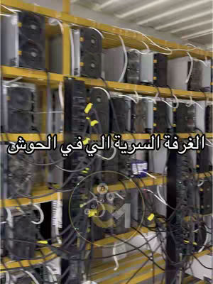 The cover image shows a server rack containing numerous computer components, likely part of a cryptocurrency mining operation. The components are dark, mounted on yellow shelving, and interwoven with numerous cables. Text in Arabic is overlayed, and a graphic with the number 1 is added.