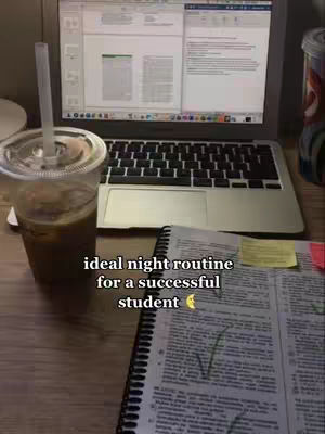 A laptop displaying a document sits on a wooden desk alongside a clear plastic cup with a brown beverage and a straw. A spiral notebook with handwritten notes and a yellow sticky note is in the foreground. The text overlay reads: 'ideal night routine for a successful student'.