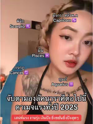 A medium shot features a young woman with fair skin and light-colored hair styled in a braided updo, with makeup including dark eyeliner and red lipstick. Overlayed on the image are text elements in various styles indicating astrological signs and related information, primarily in Thai, with some English abbreviations. The background is a blurred indoor setting with a hint of a blue surface, possibly a chair, against a neutral backdrop.