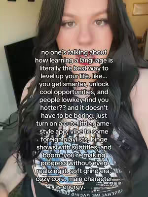 A selfie-style video shot featuring a young woman with long dark hair. She is positioned center-frame, looking towards the camera. Overlaid on the video are lines of white text, addressing the viewer directly. The background appears to be a dimly lit living space.