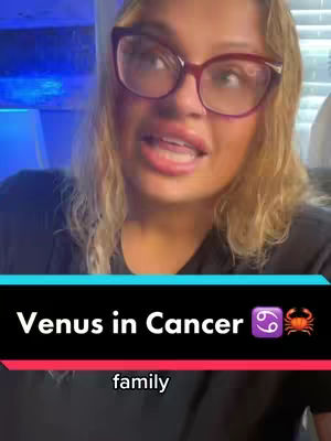 A woman with blonde hair and glasses is speaking to the camera. The background is a blurred blue. Overlaid on the image is a black bar with white text and a red bar with white text.
