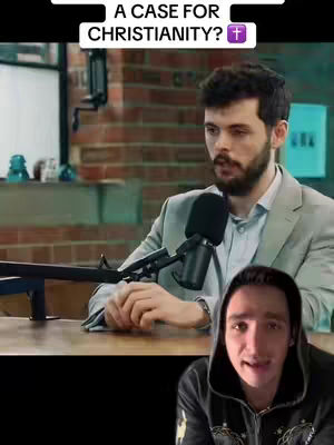 The cover image shows a split-screen. The top half features a man in a grey blazer, sitting at a desk with a microphone, possibly giving a talk. The bottom half shows a man with a black hoodie, looking directly at the camera, with a serious expression. The background includes brick and glass elements, plus a sign.