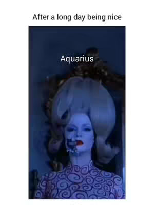 A meme-style image featuring a woman with a dramatic hairstyle and makeup, with overlaid text indicating the zodiac sign Aquarius. The woman is fair-skinned with blueish skin and a large blonde bouffant hairstyle. She wears a ornate dress, and her face has bold makeup with a dark area on one side, giving a partially obscured look.