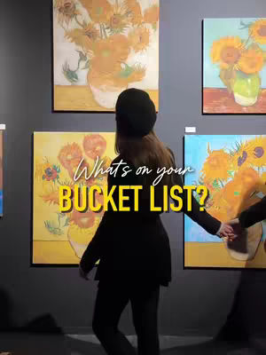 A woman stands with her back to the camera in an art gallery, admiring various sunflower paintings by Van Gogh. The central text overlay reads, 'What's on your BUCKET LIST?' The scene incorporates subdued lighting, focusing on the art and the viewer's pose.