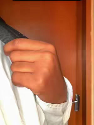 The cover image shows the right arm and hand of a person in a white shirt, holding a black coat or blazer, against an orange-brown background of what appears to be a closed door with a metallic handle.