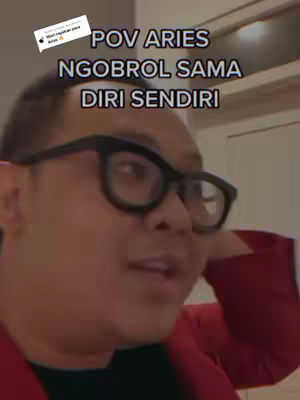 The image shows a man from the chest up, he is wearing large black frame glasses and a red blazer. Text overlays the image describing the video's theme.