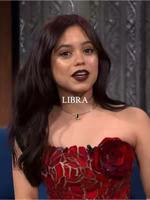 A woman with dark hair and dark lipstick looks towards the camera. The text "LIBRA" is overlaid across the image.