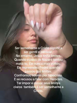 A woman is holding up her right hand, with the fingers pointing upwards with her nails painted white. Text is overlayed in the middle of the frame. The background is a blurry, dark setting.
