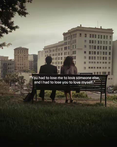 The image depicts a scene from the movie "500 Days of Summer" with two figures sitting on a park bench, overlooking a cityscape. The figures are viewed from the back, with the man on the left and the woman on the right. They sit close together. The background is comprised of various buildings. The sky is overcast. Overlayed on the image is a quote.