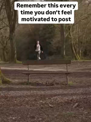 A person running, dressed in a white shirt, black jacket and grey pants, is captured in motion on a path set through a blurred, wooded setting, a wooden bench is in the middle of the view with text overlaying on the top.