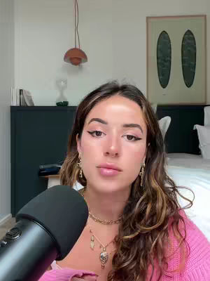 The cover image showcases a person, likely the creator, sitting in what seems to be a home studio or a well-lit room. The individual is facing the camera directly, with a microphone positioned in front of them, suggesting they are about to record or currently recording. The lighting is soft and flattering, highlighting their face. The composition is focused with depth created by the bedroom background slightly blurred.