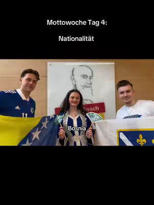 Three young people stand, each holding a flag representing their nationality. The central figure wears a traditional Bosnian outfit, holding small flags. The background features a drawing and the text 'Mottowoche Tag 4: Nationalität'.
