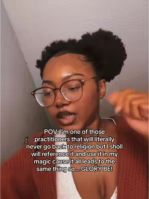 A woman with dark hair in a bun and glasses looks at the camera. Text in a white box overlayed on the image reads: 'POV: I'm one of those practitioners that will literally never go back to religion but I sholl will reference it and use it in my magic cause it all leads to the same thing so.... GLORY BE!'