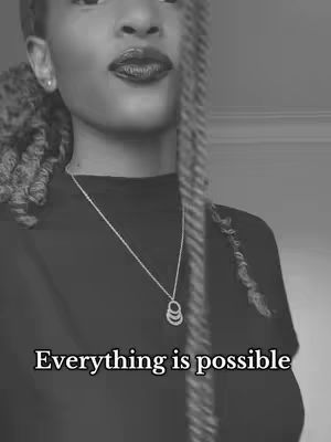 A black and white photo of a person with dark lipstick and a necklace. The overlay text states 'Everything is possible'.