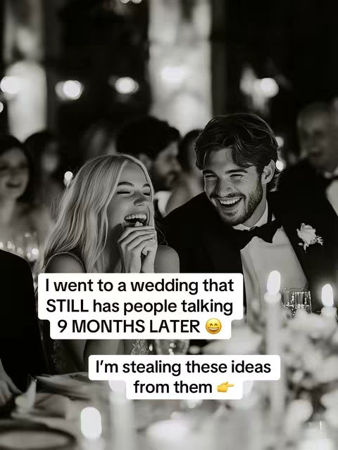 A grayscale image captures a wedding reception scene with two individuals as the focal points. A woman with blonde hair laughs and covers her mouth, while a man with dark hair smiles beside her. The background is blurred with other guests and decorative lights. Overlaid text in a white box reads, 'I went to a wedding that STILL has people talking 9 MONTHS LATER' followed by an emoji. Another white box below says, 'I'm stealing these ideas from them', with a pointing finger emoji.