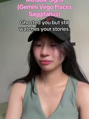 A young woman with long black hair and a black cap gazes directly at the camera with a slightly sad expression. The background appears to be a plain wall. Text overlays the image with phrases related to zodiac signs.