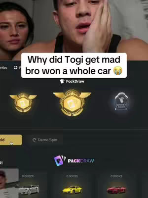 A selfie-style video with a man in the foreground and a woman in the background. Displayed at the bottom of the video are game elements, including what appears to be a prize draw or game interface. A text overlay is present at the top, along with emojis, likely for content engagement.