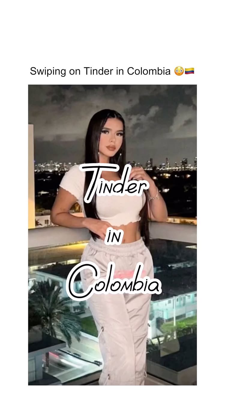 A woman stands on a balcony, with a city skyline in the background. She is wearing a white crop top and light-colored pants. The text overlay says 'Tinder IN Colombia'.