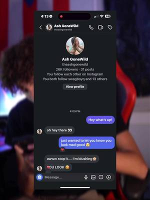 A screenshot of a phone displaying a conversation on Instagram with the profile of 'Ash GoneWild', the phone screen is overlaid on an out-of-focus background. The conversation includes messages like 'Hey what's up!' and compliments displayed.