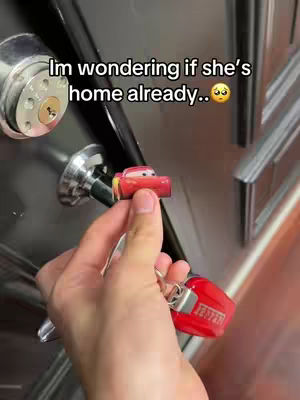 The image shows a hand holding a red car key with a miniature Lightning McQueen car attached to it, positioned near a door handle. Above the key is a text overlay.