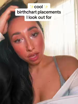 A young woman with long black hair, and a radiant blush on her cheeks. She gazes directly at the camera with a slightly open mouth, and a hand on her head. A white square houses the text overlay.