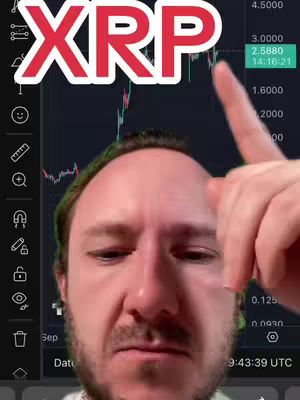 A man is pointing at a screen displaying a cryptocurrency chart, with 'XRP' overlaid as a title. The man's face fills the foreground, with a chart of green and red lines in the background, partially visible.
