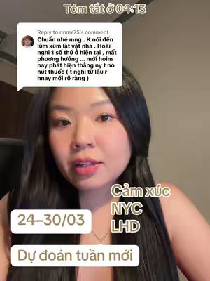 A medium shot featuring a young woman with long, dark hair centered in the frame. She is looking directly at the camera and speaking. Overlay text boxes with Vietnamese text and English abbreviations are present, along with a comment reply bubble. The background is blurred, suggesting an interior setting.
