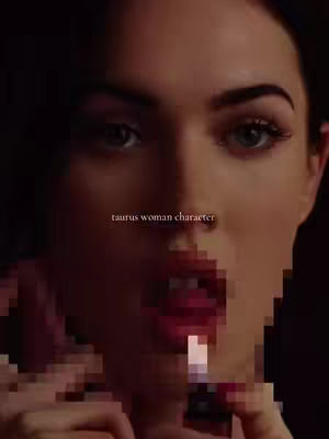 Close-up shot of a woman, likely Megan Fox, rendered in a pixelated effect. She's looking towards the viewer with a slight smile, lipstick on and her finger near her lips. The background is dark and blurry, putting the focus on her face.