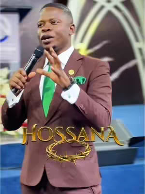A man in a brown suit with a green tie and pocket square is speaking into a microphone. Text that says "HOSANNA" is overlaid onto the image with a gold crown of thorns.