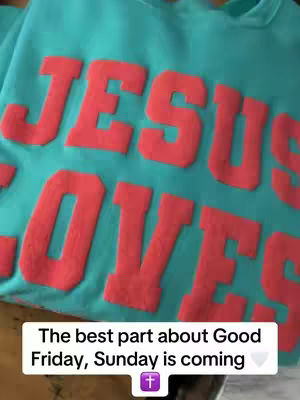 The cover image displays a close-up of a teal sweatshirt with the words "JESUS LOVES" printed in a vibrant, coral-colored, bold font. Below the text, there is a horizontal white rectangular box with the text "The best part about Good Friday, Sunday is coming" and a purple cross icon. The background is textured with the fabric of the sweatshirt.