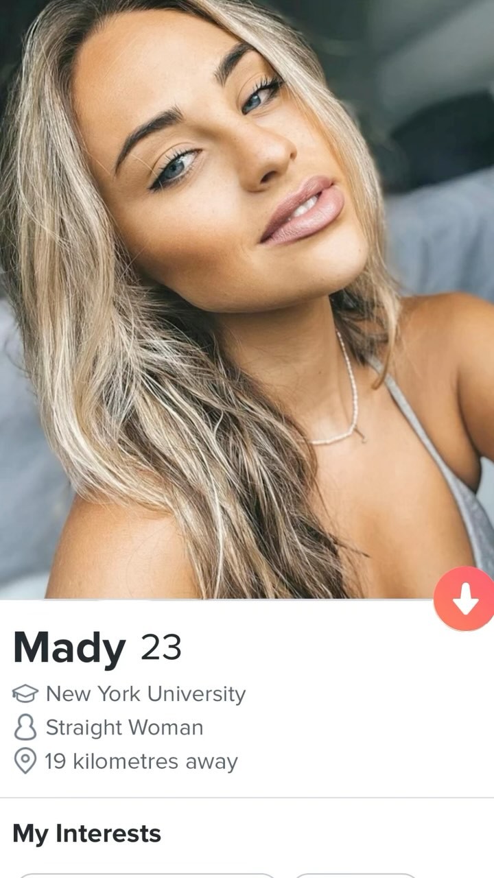 A close-up selfie of a fair-skinned woman with long blonde hair and blue eyes. She is angled towards the camera with a slight smile, and wearing lipstick. The background is blurred, and overlaid with text indicating this is a dating app profile.