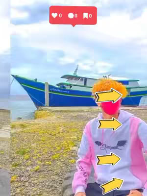 A cover image featuring a person posing in front of a boat with an Instagram like icon in the upper left corner. The person wears a white hoodie with pink accents and is gesturing with yellow arrows on their face. The boat is blue with a white top and is in the background.