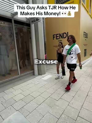 A man walks towards the camera on a tiled sidewalk, while a woman and the Fendi store sign are in the background. Text at the top of the image reads, 'This Guy Asks TJR How He Makes His Money!', with the word 'Excuse' overlaid in the video.