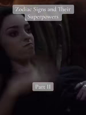 A woman's face is the main focus of the image, shot close-up and slightly angled. She gazes off to the side with a neutral expression, possibly towards the upper left of the frame. Above her, a rectangular caption reads 'Zodiac Signs and Their Superpowers' in a light color. Beneath this, in the lower portion of the image, is a square with the text of 'Part II'; both text elements employ a simple sans-serif font. The background is somewhat blurred, emphasizing her face and the overlay in the foreground.