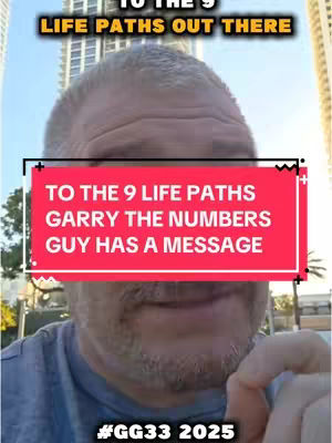 A selfie-style video cover featuring a man with short gray hair and a beard. He is positioned closely to the camera, with a red rectangular overlay covering a portion of his face, which draws focus. The background includes blurred city structures and a bright sky, suggesting an outdoor setting.