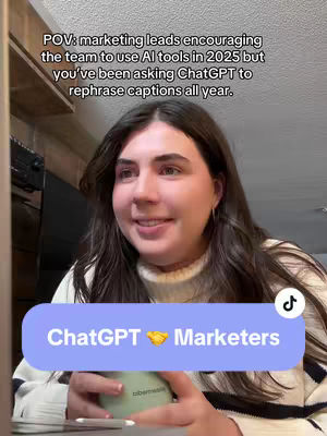 A woman with dark hair is centered in the frame, looking toward the right. Behind her are light-colored walls, and the top right corner contains a part of the ceiling and a shelf or structure with a shadow. A light blue banner with white text that says "ChatGPT 🤝 Marketers" is placed just below her chin. A green and white cylindrical object that appears to be a water bottle or beverage container is in her hand. At the top left of the image is a text overlay which reads, "POV: marketing leads encouraging the team to use AI tools in 2025 but you've been asking ChatGPT to rephrase captions all year."